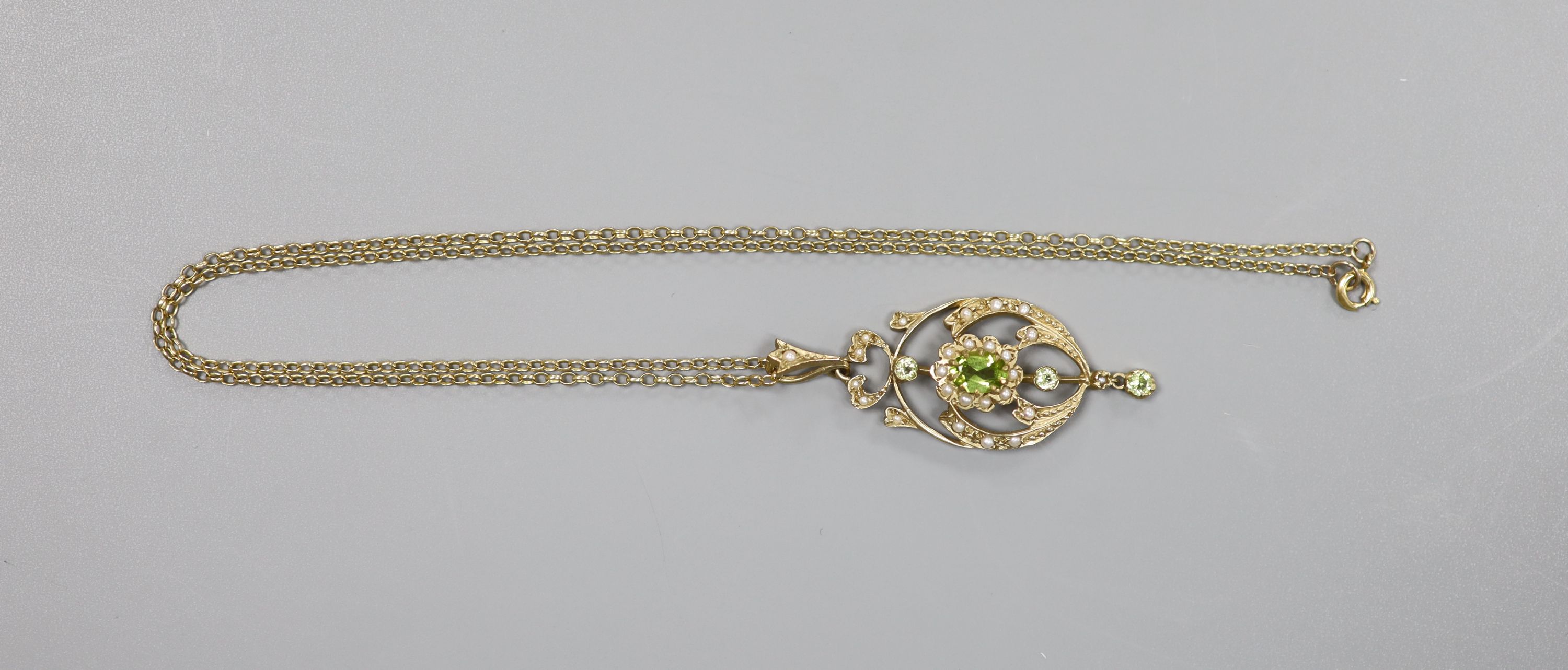 A modern 9ct gold, peridot and seed pearl set drop pendant, 47mm, on a 9ct chain, 46cm